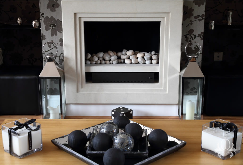 contemporary fireplace is accentuated by carefully selected accessories to make a stunning focal point for this glamorous Weybridge home.